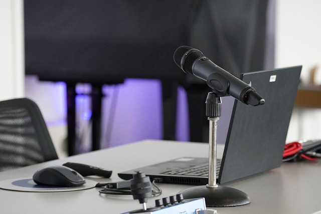 A podcast setup includes a microphone next to a laptop.